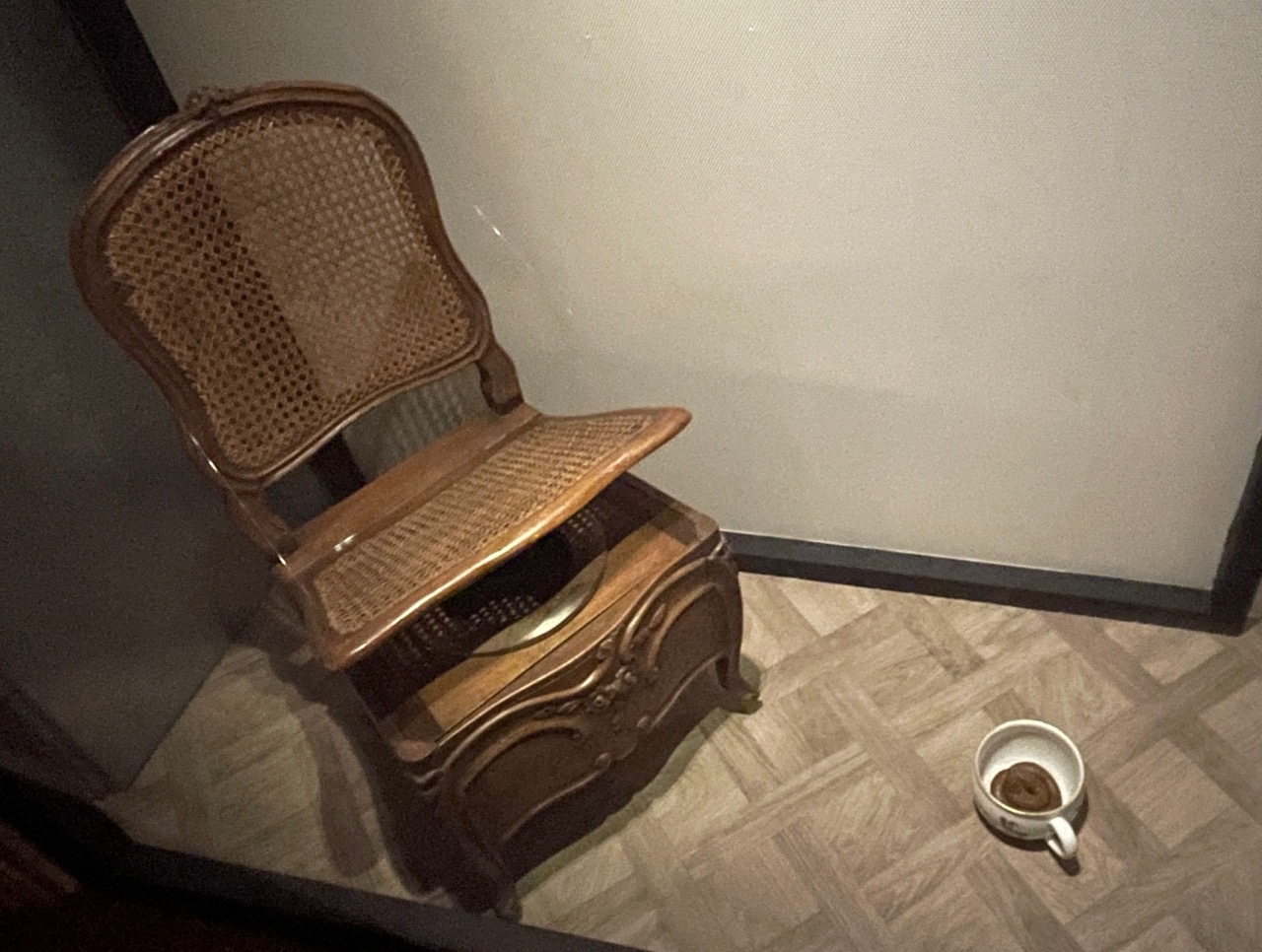 Chaise d’affaires du XVIIIe siècle présentée ouverte, avec à terre le pot contenant une selle, dans l’exposition du Musée des Arts décoratifs de Paris.